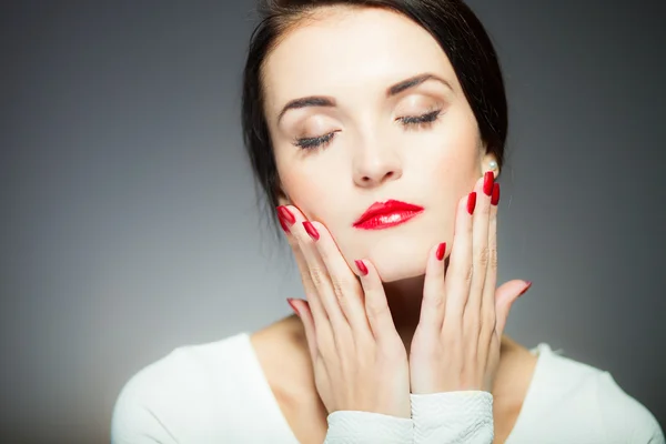 Femme naturelle visage avec des ongles rouges et les lèvres — Photo