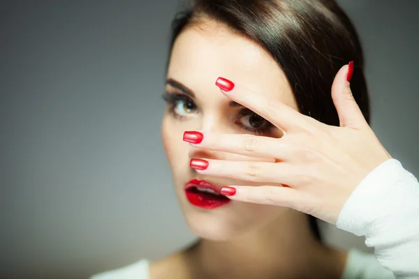 Femme naturelle visage avec des ongles rouges et les lèvres — Photo