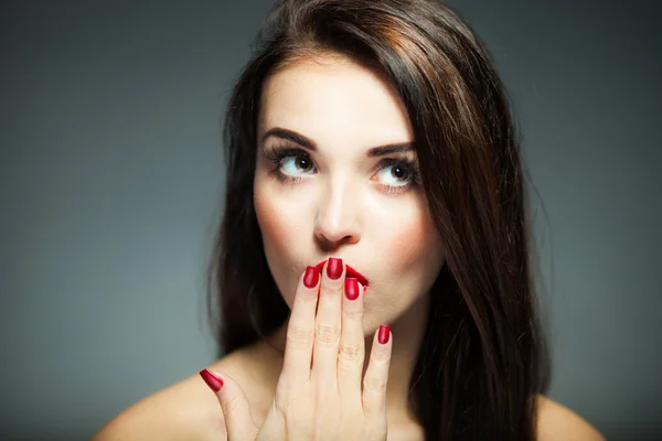 Женское лицо с красными ногтями и губами — стоковое фото
