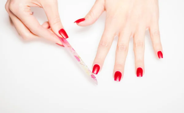 Girl hand manicure with nail file on bright background — Stock Photo, Image