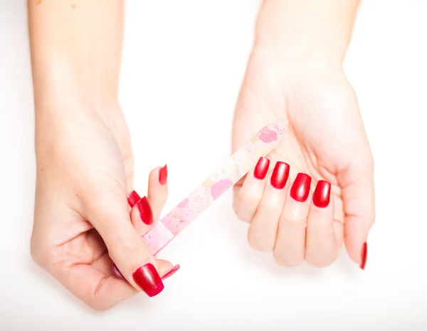 Girl hand manicure with nail file on bright background — Stock Photo, Image