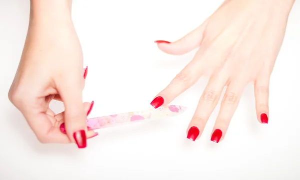 Girl hand manicure with nail file on bright background — Stock Photo, Image