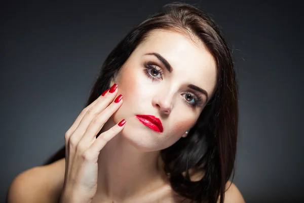 Femme naturelle visage avec des ongles rouges et les lèvres — Photo