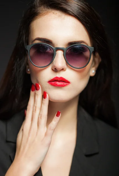 Glamour vrouw met zonnebril, rode lippen en nagels — Stockfoto