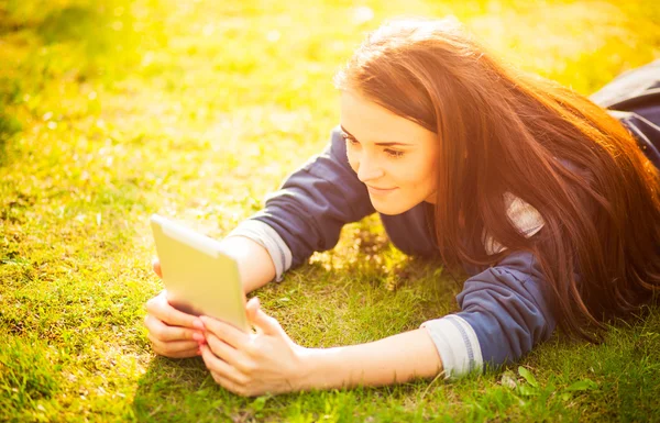 Schönes Mädchen mit Tablet oder eBook im Freien auf dem Feld — Stockfoto