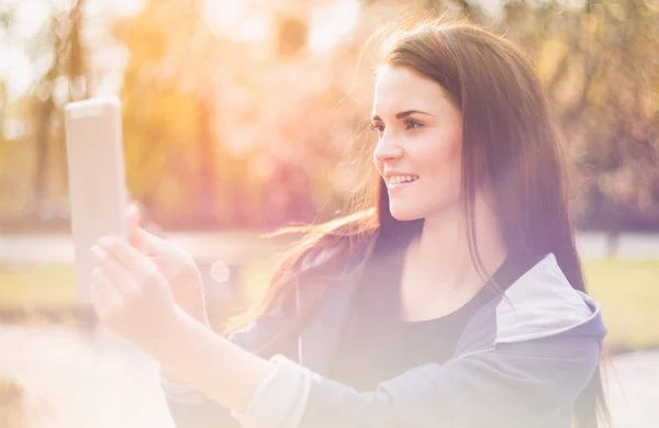 Beautiful girl with tablet or ebook outdoor — Stock Photo, Image