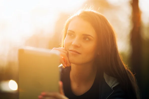 Menina bonita com tablet ou ebook ao ar livre — Fotografia de Stock