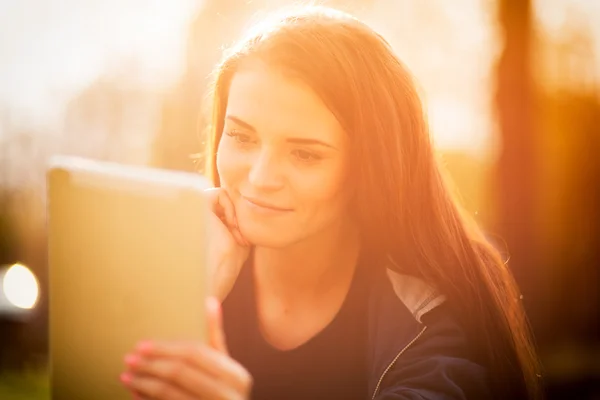 Menina bonita com tablet ou ebook ao ar livre — Fotografia de Stock