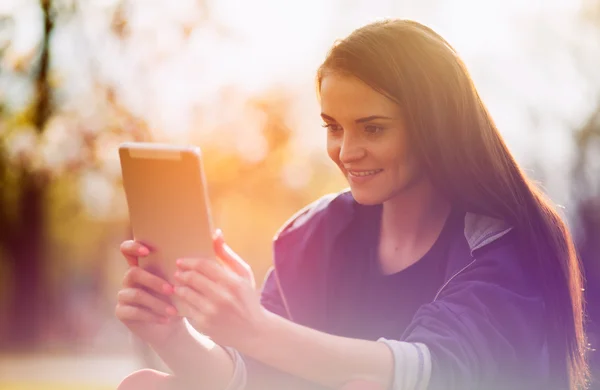 Belle fille avec tablette ou ebook en plein air — Photo