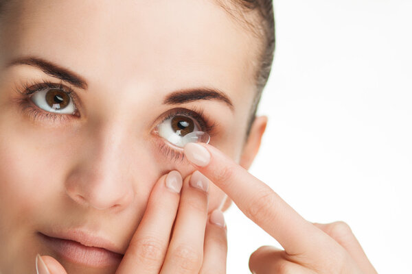 Woman putting contact lens in her eye