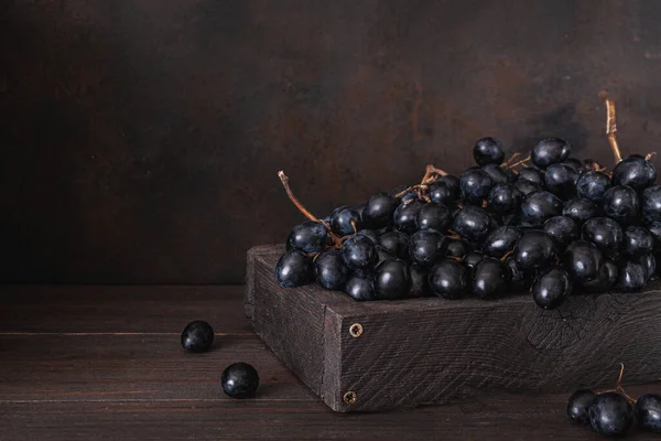 Fresh Dark blue purple grape in wooden box isolated on wooden table. Wine grapes, table grapes. Exotic fruit. Top view