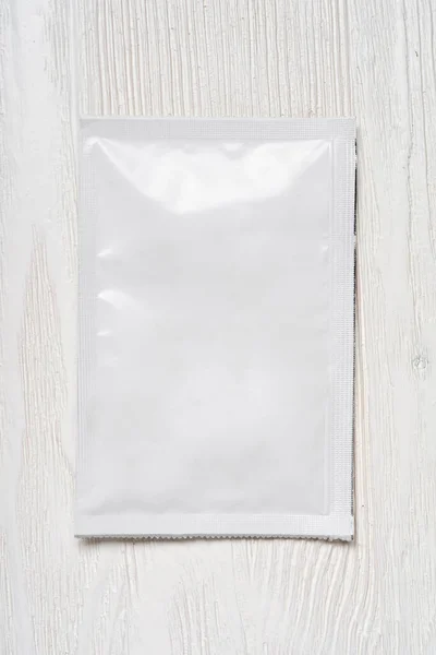 木製のテーブルの上に白い空白の紙の袋 デザインのためのモックアップテンプレート — ストック写真