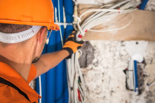 白人建筑承包商 40多岁 头戴硬帽 看着里面的电气设备 抓起电缆 工业主题 — 图库照片