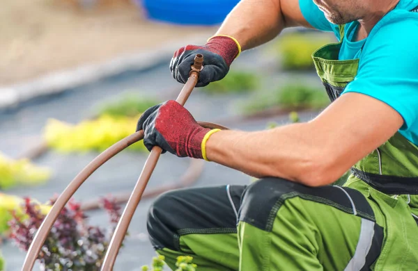 白种人专业园艺师接驳花园灌溉系统的塑料管材 花园科技 — 图库照片