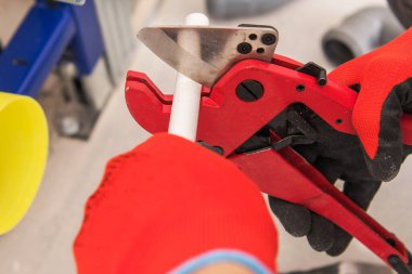 İnşaat Endüstrisi Ekipmanı. Plastik Su Boru Hattı Kesme Aracı. Erkekler Boru Uzunluğunu Ayarlıyor Yakın plan.