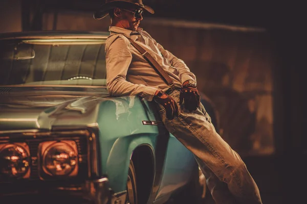 37歳のカウボーイは 革の西洋スタイルの帽子と手袋と彼の古典的なヴィンテージ車を身に着けています 自動車のテーマ — ストック写真