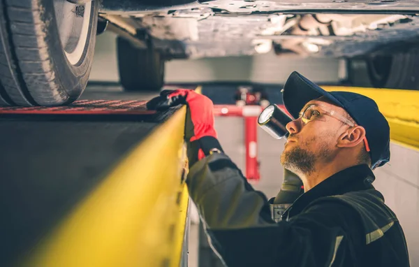 Vit Bil Mekaniker Årsåldern Med Ficklampa Spotting Fordon Suspension Problem — Stockfoto