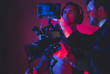 Geniş Dijital Depolama Ekranı 'nda Yeni Çekilen Görüntü İncelemesi için İki Kafkas Adam Kamera Ekibi Danışmanı. Dijital Video Sanayi TemasıName.