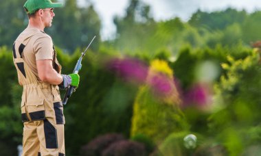 Arka bahçesinde makası olan 40 'lı yaşlarda profesyonel bir beyaz bahçıvan. Bahçe düzenleme ve Bahçe Sanayii.