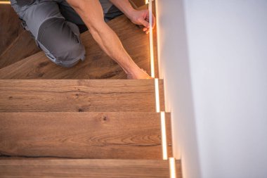 Profesyonel Kafkasyalı İşçi LED Residential Wooden Stairs Lights Installation 'ı bitiriyor. Modern Ev Aydınlatma Teknolojileri.