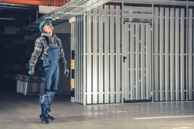 Kafkas Tesisatçısı, Su Boru Hattı ile Potansiyel Sorunlar Arıyor. Ticari Binalar Tesisat işi. Endüstriyel Tema.