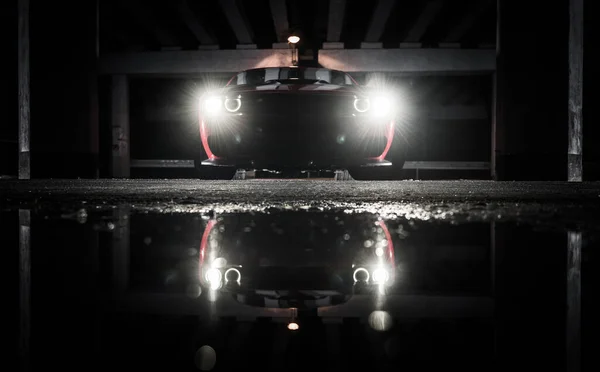 Vorderseite Eines Muscle Cars Zwischen Betonbrückenteilen Während Der Nachtstunden Wasserspiegelungen — Stockfoto