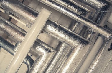 Bodrum katındaki izole borular. Yakın plan fotoğraf. Sanayi Elementleri.