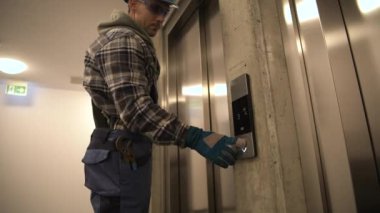 Asansörü çağıran profesyonel teknisyen. Konut Asansörünün Zamanlanmış Garanti Bakımı.