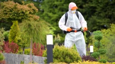 Beyaz tenli profesyonel bahçıvanın bahçe bitkileri böcek ilacı. Bahar Zamanı Arka Bahçe Bakımı.