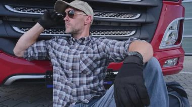 Ulaşım Endüstrisi. 40 'lı yaşlarındaki Kafkas Kamyoncu Gerekli Sürüş Molasında Yarı Kamyonetinin yanında Dinleniyor.