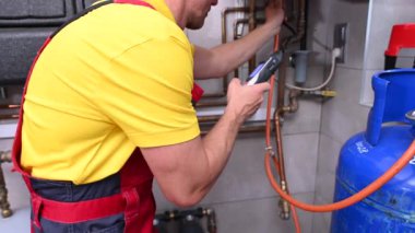 HVAC Worker Looking For Gas Leaks Inside Residential Heater