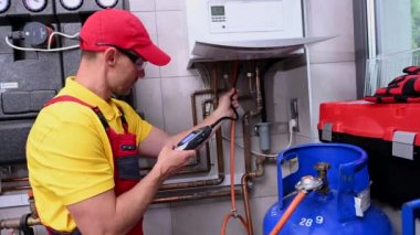 Professional Caucasian HVAC Worker Looking For Gas Leaks Inside Home Heater