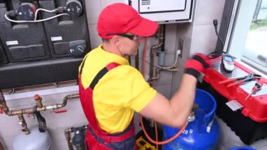 Modern Merkezi Gaz Isıtıcı Elektronik Tamiri. Kafkasyalı HVAC teknisyeni ısıtıcının içine bakıyor. Endüstriyel Tema.