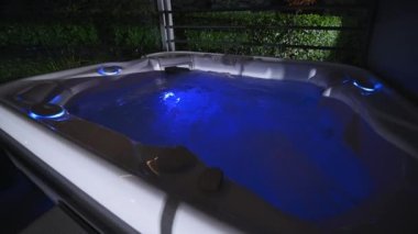 Running Modern Residential Hot Tub Illuminated by Blue LED light
