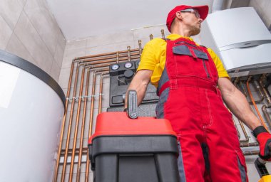 Doğal Gaz Isıtma Sistemi Kontrolü Yapan Yerli Sağlık Hizmetleri İşçisi. Elinde alet çantası olan beyaz bir teknisyen.. 