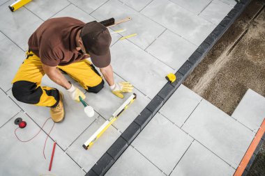 Profesyonel Kafkas işçisi beton döşeme tuğlaları döşemesi. Endüstriyel Tema.