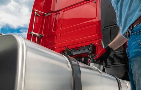 Caucasian Semi Truck Driver Refueling His Tractor Vehicle Close Up Photo. Heavy Transportation Industry Theme.