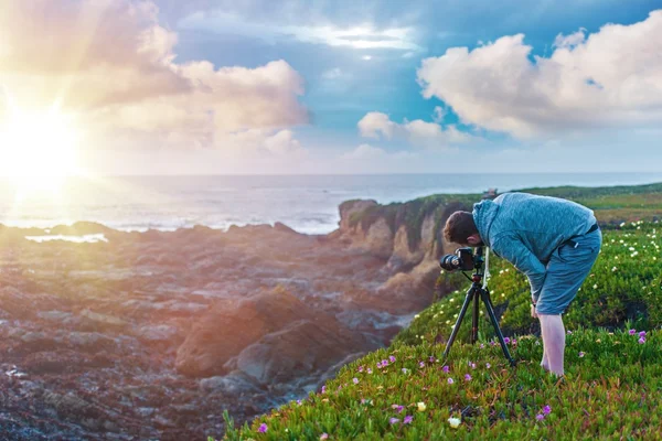 Фотографії природи. фотограф на скелі океан, захід сонця фотографувати — стокове фото