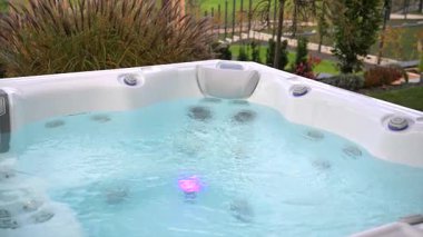 İnsanlar güneşli bir günde bitkilerle çevrili bir jakuzide vakit geçirmeyi severler..