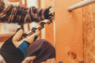 Bir işçi, bir elinde matkap ucu ile odunu deliyor. Odak noktamız elimizdeki görev..