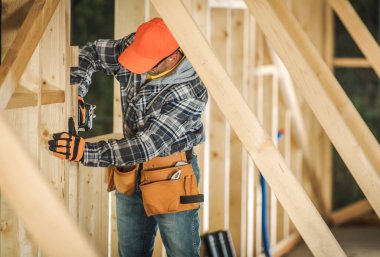 Güvenlik donanımı işçisi, gün içinde inşaat alanındaki aletleri kullanarak bir duvar inşa eder..