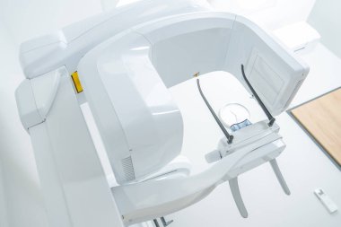 A dental machine awaits in a bright clinic room, surrounded by clean, organized tools for patient use.