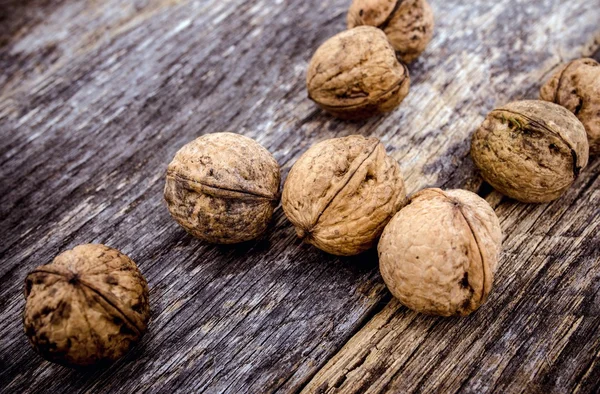 Nueces crudas sobre tabla de madera envejecida — Foto de Stock