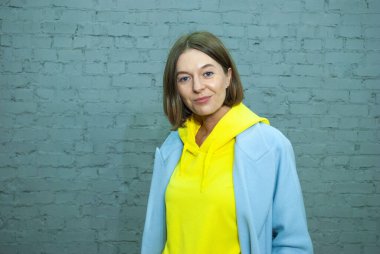 Sokak duvarında izole edilmiş paltoyla güzel bir kız portresi, kadın kentsel giyim tarzı.