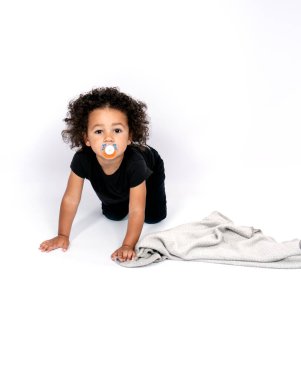 Melez bir ırkın dikey portresi. İki buçuk yaşında bir çocuk emeklerken meme ucunu emiyor.