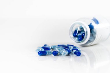 Beyaz zemin üzerinde izole mavi tıbbi kapsüllerin yakın çekim