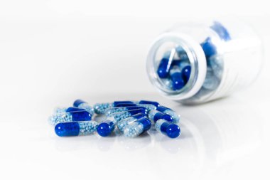 Beyaz zemin üzerinde izole mavi tıbbi kapsüllerin yakın çekim