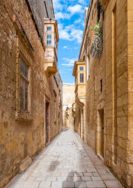 Mdina, Malta 'da tarihi kireçtaşı binalar ve geleneksel balkonlarla dolu büyüleyici dar bir cadde..