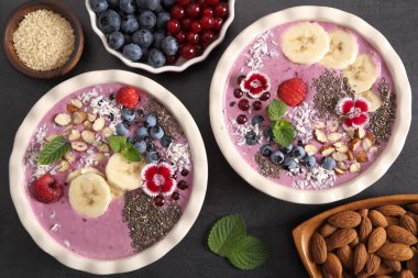 Yabanmersinli meyve suyu kasesi, üzümlü, chia tohumlu, muzlu ve bademli. Üst görünüm.