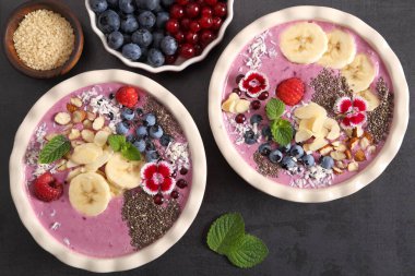 Yabanmersinli meyve suyu kasesi, üzümlü, chia tohumlu, muzlu ve bademli. Üst görünüm.